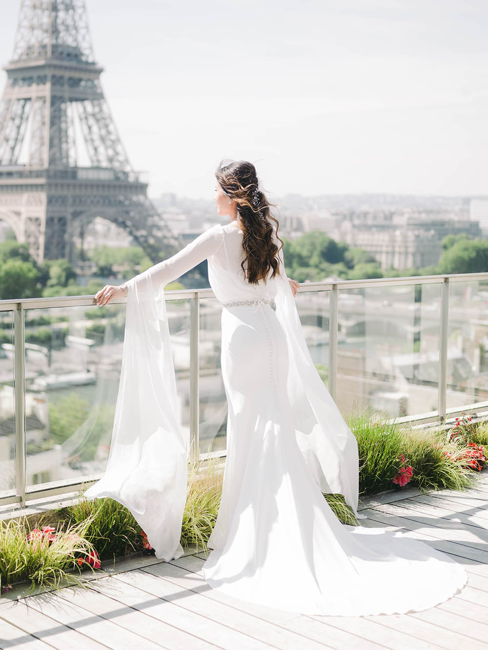 une mariée regarde la stour eiffel sur le terrase du shangri la 